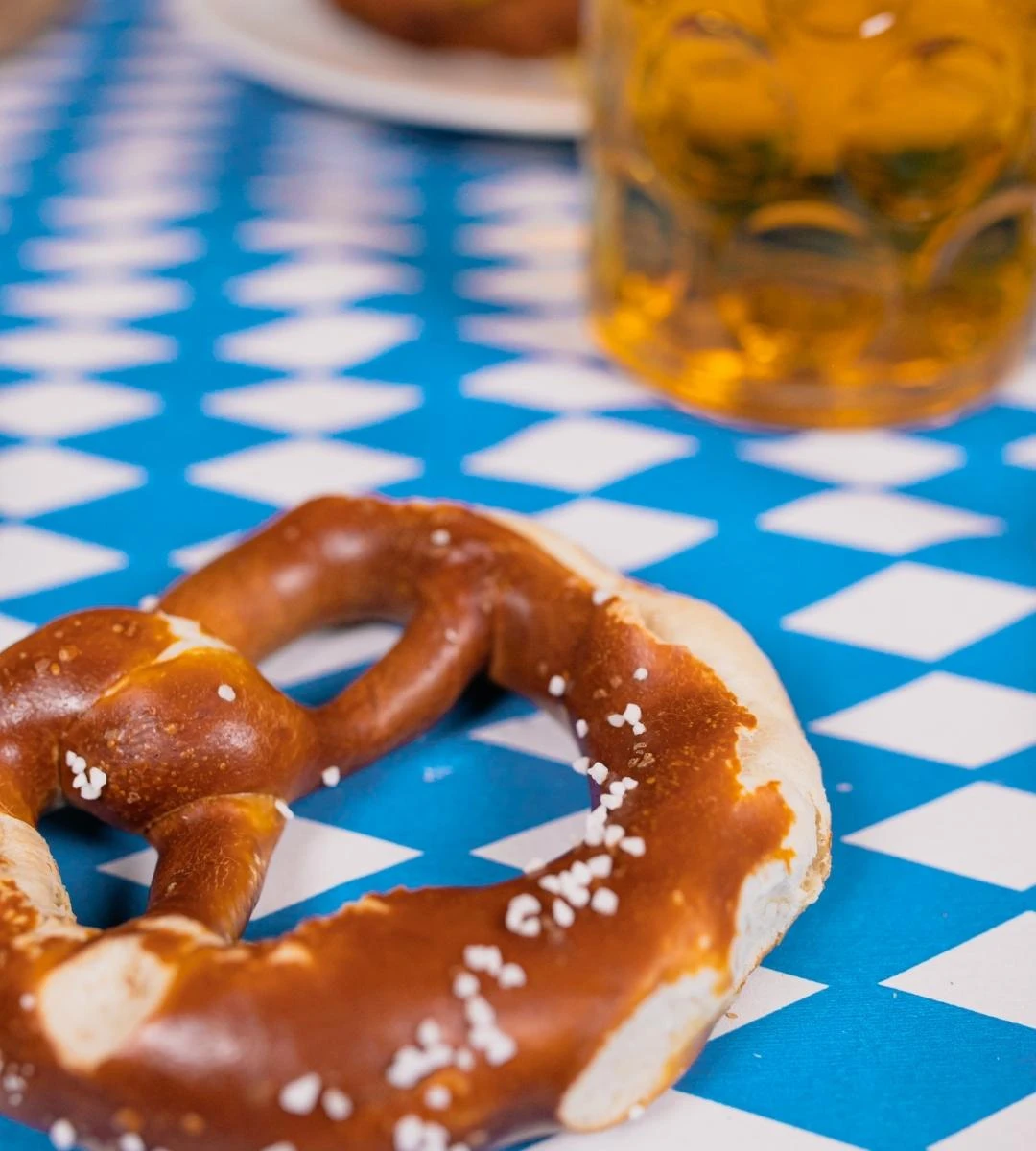 Великі зміни на Oktoberfest 2025: безготівкові платежі, дорожче пиво та нові атракціони – усе, що потрібно знати 2 Ціни на пиво на Октоберфесті у 2025 році. На фото: на столі лежить брецель.